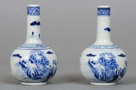 A pair of 19th century Chinese blue and white bottle vases Decorated in the round with hills and