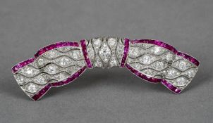 A ruby and diamond set brooch Of bow form. 5 cm wide.