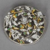 A circular 18 ct gold, white gold, diamond and emerald filigree brooch
Approximately 2 carats