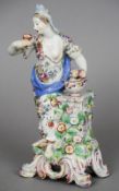 A 19th century porcelain figure Formed as a loosely clothed lady in floral dress standing beside a