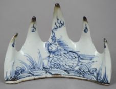 A Chinese porcelain blue and white brush rest
Decorated with a dragon and floral sprays.  11 cm