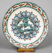An Iznik style pottery plate Centred with a roundel of animal decoration, the underside with black