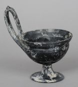 A Roman basalt handled pedestal bowl
The handle decorated with a figural mask.  13 cm diameter.