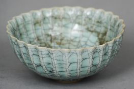 A small Chinese celadon crackle glaze bowl
Of crimped form, the underside with a seal mark.  12.5 cm