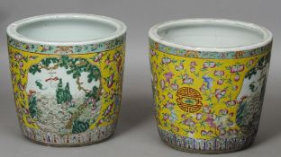 A pair of Chinese porcelain jardinieres
Each with scenic vignettes on a yellow ground.  Each 38 cm