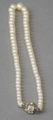 A cultured pearl single-row necklace 
Set with an unmarked gold and diamond clasp.  49 cm long.