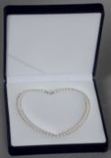 A Chinese cultured pearl necklace
With white metal clasp stamped Silver, in fitted case. CONDITION