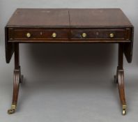 A 19th century mahogany sofa table
The twin flap top above two frieze drawers with opposing dummy