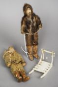 A pair of model Inuit Eskimos
Each with seal skin clothing, the female figure with a baby in her