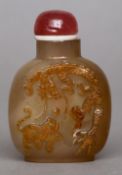 A Chinese carved russet jade snuff bottle
Of typical form, the front decorated with a dragon and a