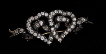 A late 19th century unmarked gold and silver, diamond set sweetheart brooch
Formed as a pair of