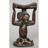 An African carved wooden tribal headrest
Formed as a crouching female figure.  20 cm high.