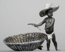 A cold painted model of a Negro fishing boy
Standing beside a basket of fish.  11.5 cm wide.