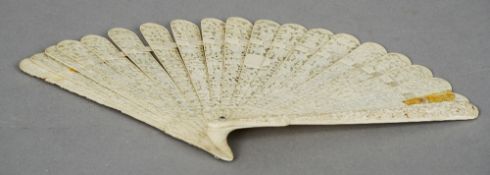 A Chinese carved ivory fan
The guards profusely carved with figures, the staves similarly carved and