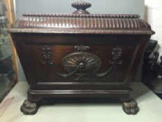 An 18th century style mahogany cellaret
The finial mounted removable lid above the carved panelled