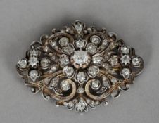 A Victorian unmarked gold and silver diamond set brooch
Of pierced scrolling form,