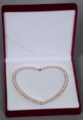 A Chinese cultured pink pearl necklace
With white metal clasp, stamped 925, in fitted case.