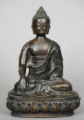 An antique Chinese patinated bronze model of Buddha Typical modelled and seated in the lotus