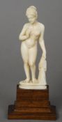 A small late 19th/early 20th century carved ivory model of a nude lady
Standing on a wooden plinth