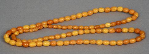 An amber bead necklace Each bead of oval form. Approximately 92 cm long. CONDITION REPORTS: