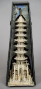 A large intricately carved Chinese ivory model of a tower
With figures in the foreground, housed