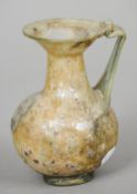 A Roman antiquity glass jug
With flared neck rim and scrolling angular handle.  12 cm high.