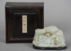 A Chinese carved pale and russet jade scholar's boulder Worked as figures in a mountainous