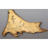A small piece of scrimshawed elk or caribou antler
Decorated with an elk towing a sled, figures