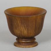 A carved horn bowl
Of flared form, with a shallow interior, standing on a turned base.  12 cm