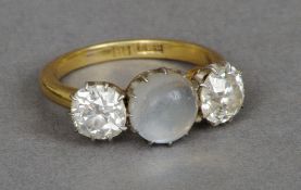 An early 20th century 18 ct gold moonstone and diamond three stone ring
The central cabochon