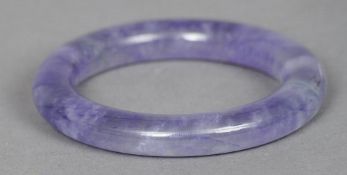 A Chinese carved lavender jade bangle
Of typical form.  8.5 cm diameter. CONDITION REPORTS: