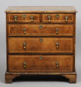 An 18th century walnut chest of drawers
The moulded rectangular top with feather banding above an