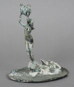 A patinated bronze model
Formed as a mermaid rising from the sea holding aloft a clam shell followed