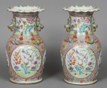 A pair of 19th century Chinese vases
Each decorated with dogs-of-fo and dragons above vignettes of