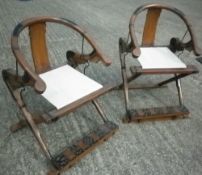 A pair of Chinese hardwood metal mounted folding chairs
Each with a curved back rail above the