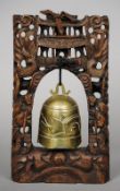 A Chinese bell
Mounted on a carved and pierced wooden pierced wooden stand.  36 cm high. CONDITION