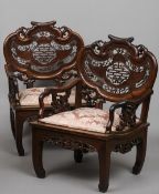 A pair of Chinese rosewood open armchairs
The pierced scrolling shaped backs above pierced open arms