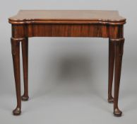 A George II mahogany card table
With fold over top, standing on tapering legs with pad feet.  84