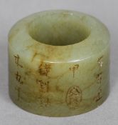 A Chinese carved jade archers ring
Decorated in the round with calligraphy.  2.25 cm high. CONDITION