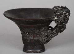 A Chinese carved horn libation cup
The handle worked as a stylised bat, the body with carved