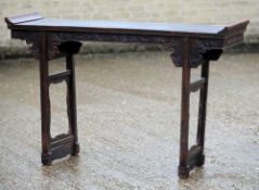 A Chinese carved hardwood altar table
Of typical rectangular form with a carved frieze and square