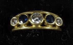 A diamond and sapphire set yellow metal ring
The central stone approximately 0.25 carat. CONDITION