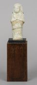 An Egyptian shabti figure
In typical pose, with remnants of faience glaze, mounted.  23.5 cm high