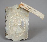 A Victorian mother-of-pearl and ivory aide memoire 
The cover well carved with a portrait of a busty