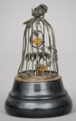 An unmarked silver filigree novelty desk timepiece
Formed as birds in a cage, on an ebonised domed