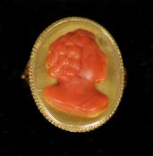 A 19th century red coral and yellow metal ring
Carved with the bust of a young lady, in fitted