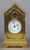 A gilt brass cased mantel clock
The white dial with Roman numerals, a glazed aperture above