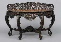 A 19th century Burmese carved hardwood demi-lune side table
The shaped top with a carved gallery