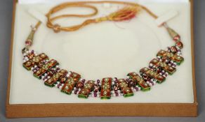 An Indian pearl and ruby set enamel decorated necklace
Each enamel section interspersed with