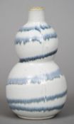 A Chinese porcelain double gourd vase
With allover drip glaze, incised marks to base.  20.5 cm high.